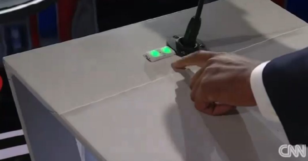 CNN's Victor Blackwell points to green lights on a podium that will be used for the presidential debate in Atlanta.