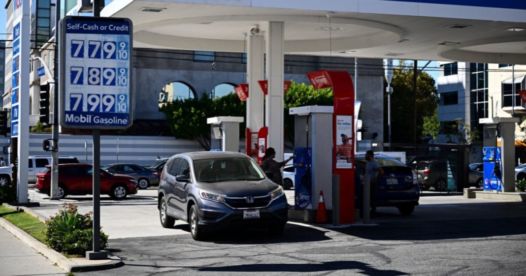 A customer uses a credit card to pump gas as a sign shows gasoline fuel prices above average at over seven and approaching eight dollars a gallon at a Mobil gas station in Los Angeles, California, on October 5, 2023.