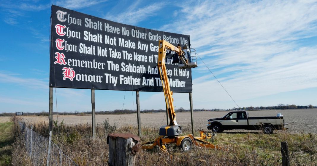 Workers repaint a Ten Commandments billboard off of Interstate 71near Chenoweth, Ohio, Tuesday, Nov. 7, 2023. Louisiana has become the first state to require that the Ten Commandments be displayed in every public school classroom under a bill signed into law Wednesday by Republican Gov. Jeff Landry.