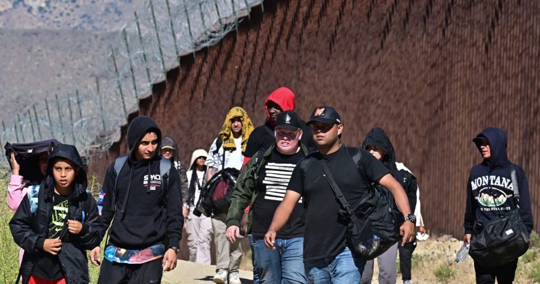 Illegal Immigrants walk on the U.S. side of the border wall in Jacumba Hot Springs, California, on June 5, 2024, after walking across from Mexico.