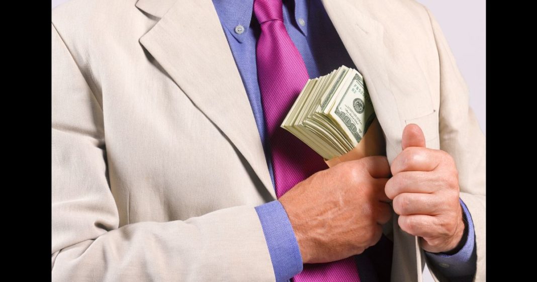 This Getty stock image shows a man suspiciously pocketing a large wad of cash.