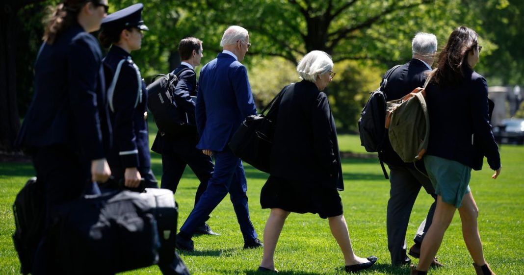 President Joe Biden, fourth from left, is accompanied by staff, including Deputy Chief of Staff Bruce Reed and senior advisers Anita Dunn and Mike Donilon, as they depart the White House in Washington on April 23.