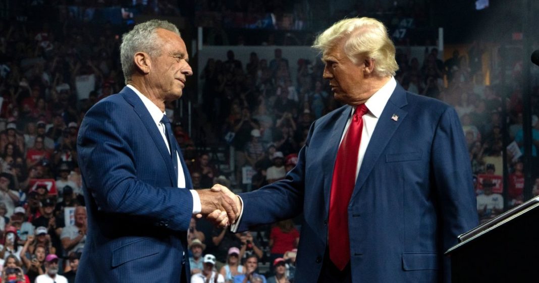 Former Republican presidential candidate Robert F. Kennedy Jr. and Republican presidential nominee, former U.S. President Donald Trump shake hands during a campaign rally.