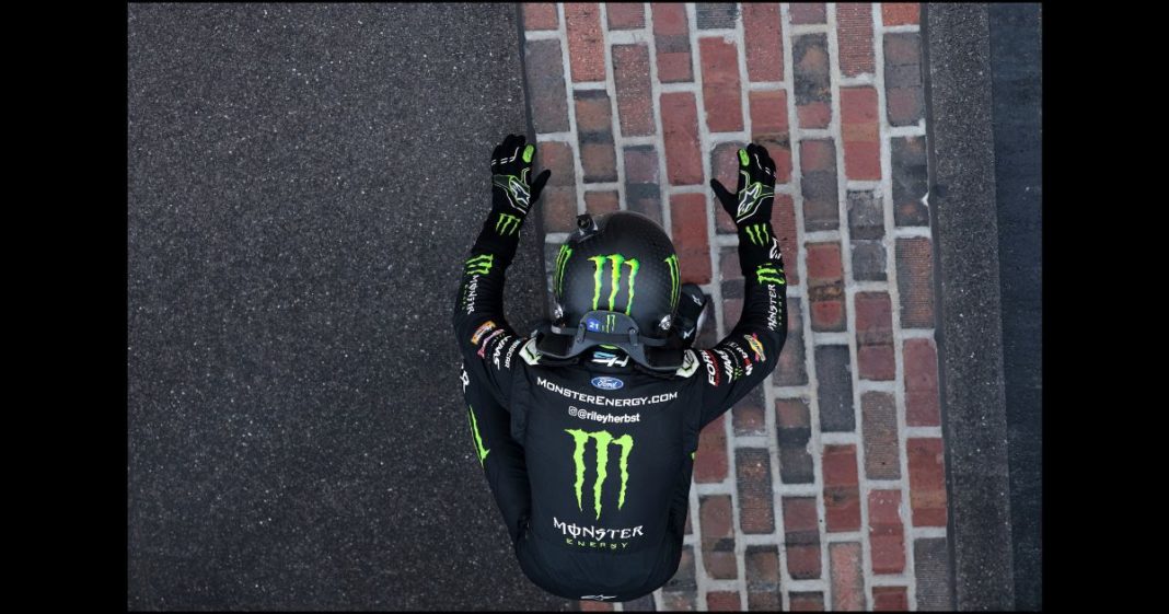 Riley Herbst, driver of the #98 Monster Energy Ford, celebrates after winning the NASCAR Xfinity Series Pennzoil 250 at Indianapolis Motor Speedway on July 20, 2024 in Indianapolis, Indiana.