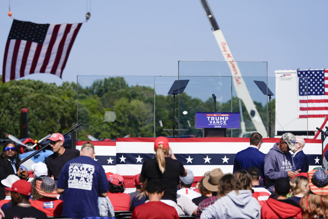 An outdoor stage is set encased with bulletproof glass as supporters arrive to hear Republican presidential nominee former President Donald Trump speak at a rally on Wednesday in Asheboro, North Carolina. Trump is holding his first outdoor rally since narrowly surviving an attempted assassination when a a gunman opened fire in Pennsylvania last month.