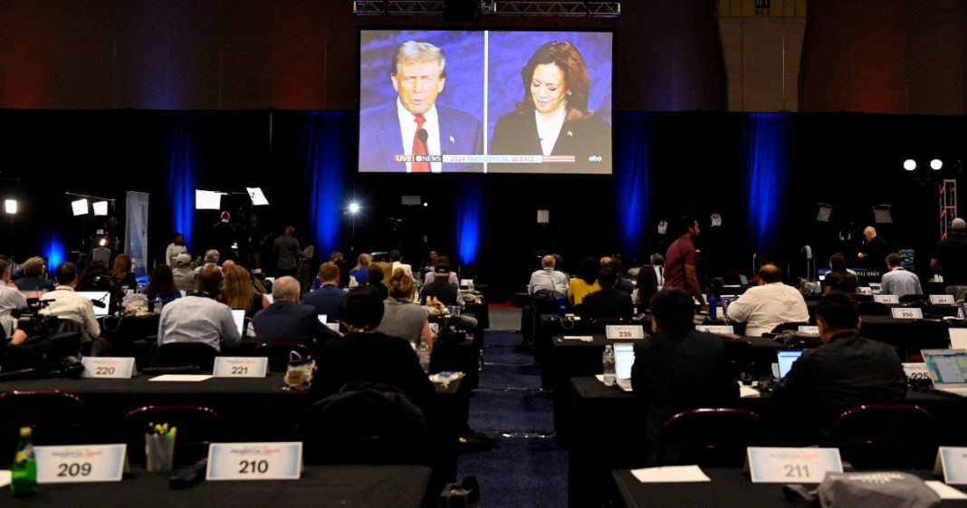 Journalists and members of the media watch former President Donald Trump and Vice President Kamala Harris debate from the spin room in Philadelphia, Pennsylvania, on Tuesday.