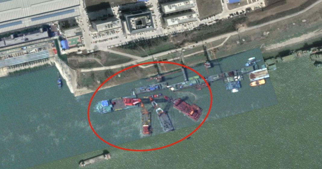 A defense analyst posted photos of crane barges surrounding a "submarine-shaped" object under the water.