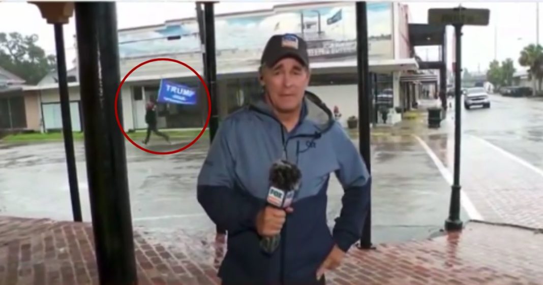 During a Fox News weather report in Morgan City, Louisiana, a supporter of former President Donald Trump, circled, ran behind the reporter with a Trump flag, prompting him to cover the screen.