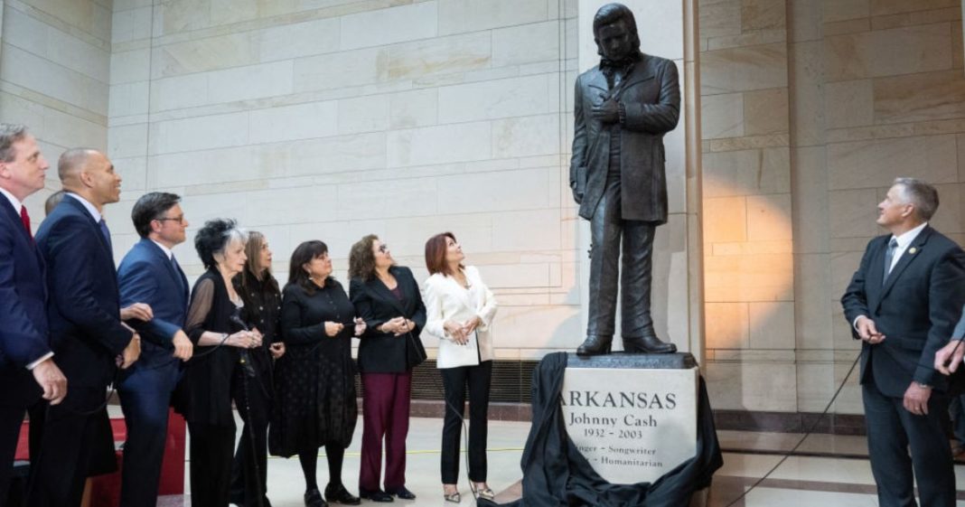 A statue of country music singer and Arkansas native Johnny Cash is unveiled Tuesday as House Minority Leader Hakeem Jeffries (second from left), Democrat of New York, and Speaker of the House Mike Johnson (third from left), alongside members of the Cash family, watch in Emancipation Hall on Capitol Hill in Washington, D.C..