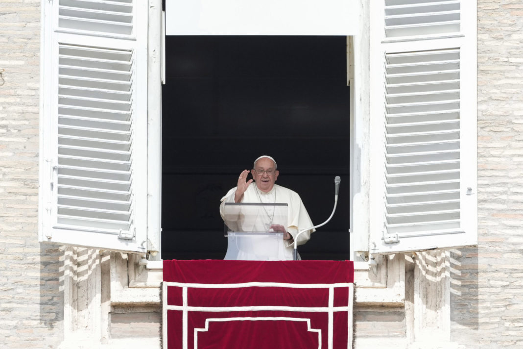 Pope Francis waves from the window of his studio overlooking St.Peter's Square during the Angelus noon prayer at the Vatican on Sunday.