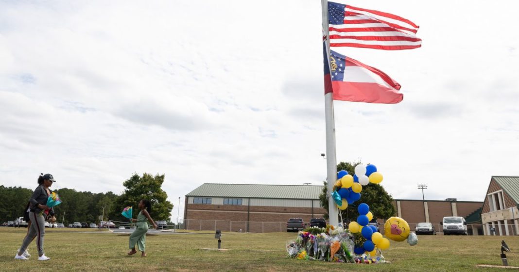 Community members visit a makeshift memorial at Apalachee High School Thursday in Winder, Georgia. Two students and two teachers were shot and killed at the school Wednesday. A 14-year-old suspect, who is a student at the school, is in custody.