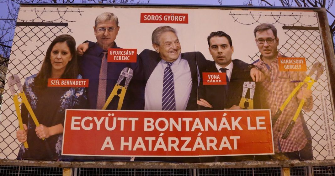 A Fidesz-party sponsored poster featuring a montage of billionaire investor George Soros (C) posing with (L to R) Politics Can Be Different (Lehet Mas a Politika, or LMP) party candidate Bernadett Szel, former Hungarian prime minister and Democratic Coalition (Hungarian: Demokratikus Koalicio, or DK) party candidate Ferenc Gyurcsany, Jobbik party candidate Gabor Vona, and Dialogue for Hungary (Parbeszed Magyarorszagert) party candidate Gergely Karacsony, all holding bolt cutters after having cut the border fence behind them, hangs prior to the upcoming Hungarian parliamentary elections on April 8, on March 20, 2018 in Budapest, Hungary.