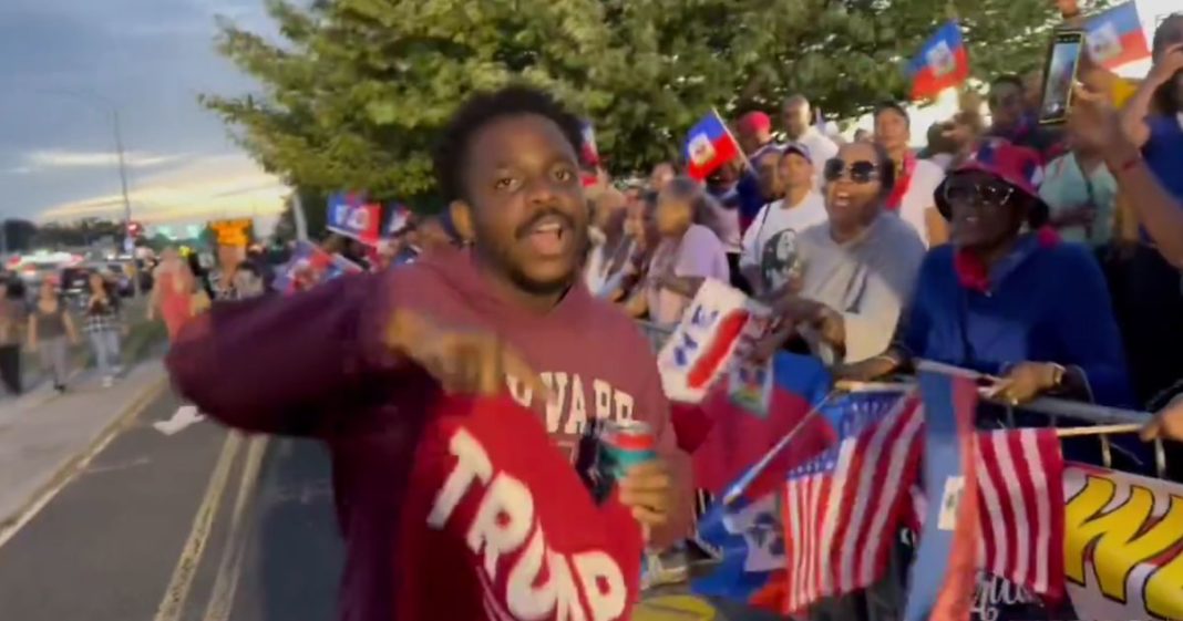 A black Trump supporter confronts Haitian protesters outside the former president's New York rally Wednesday.