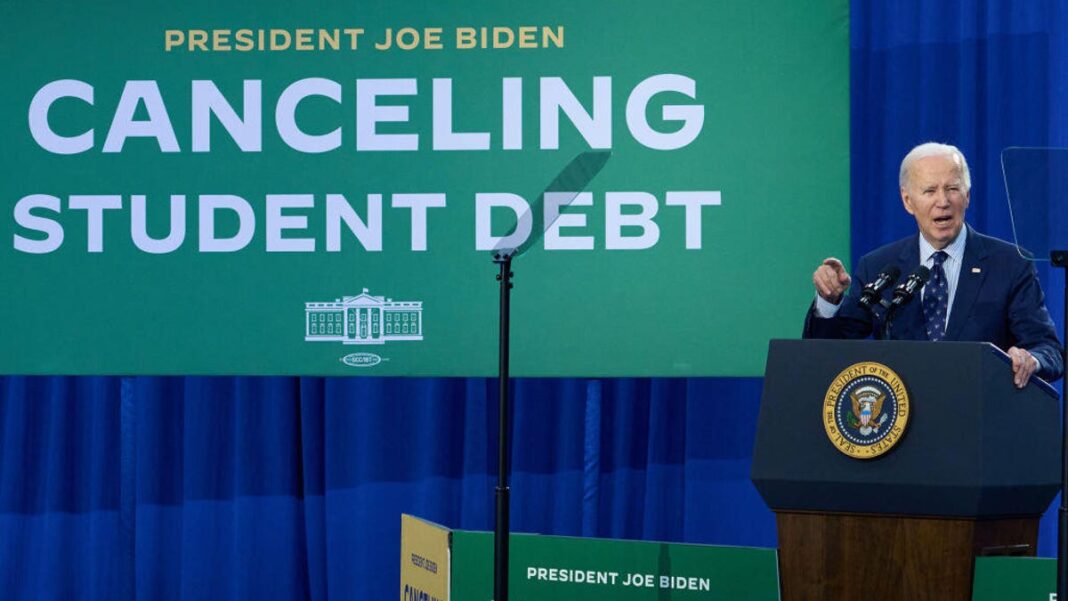 President Biden giving a speech in front of a green sign that says "canceling student debt"