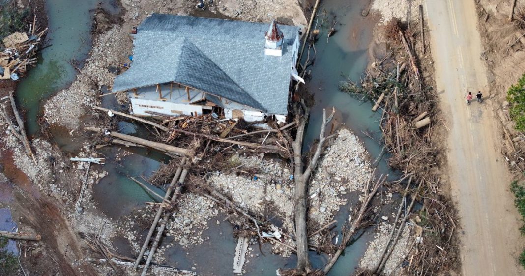 An aerial view shows people walking past a destroyed church in the aftermath of Hurricane Helene flooding in Swannanoa, North Carolina, on Sunday.