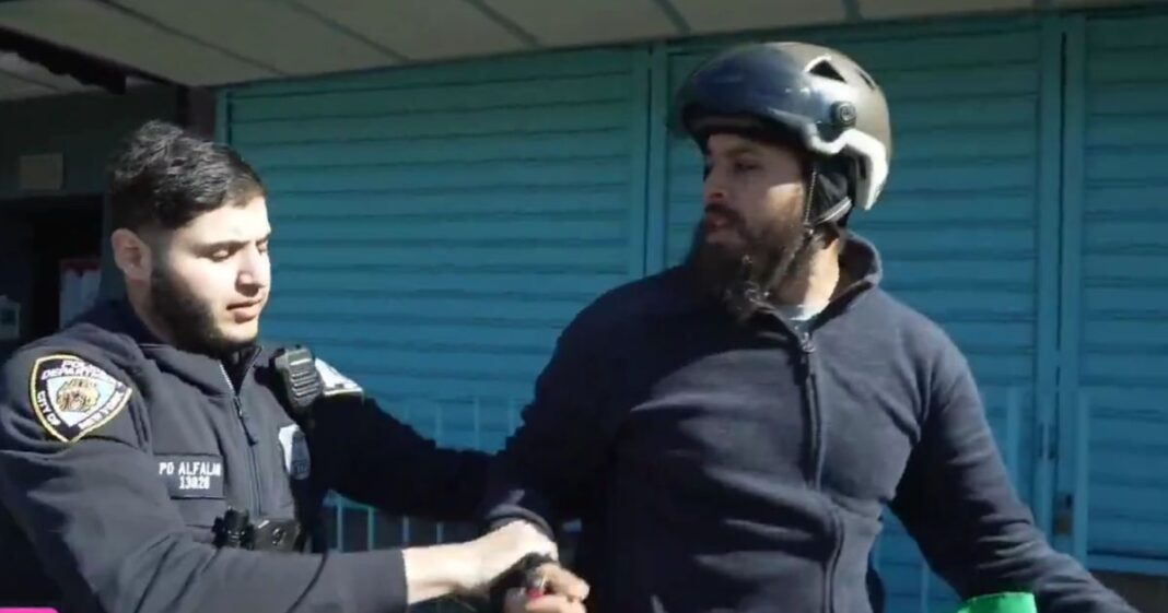 The bicycle-riding protester shouted "Free Palestine" and attempted to burn what appeared to be an Israeli Defense Forces flag until he was detained by police.